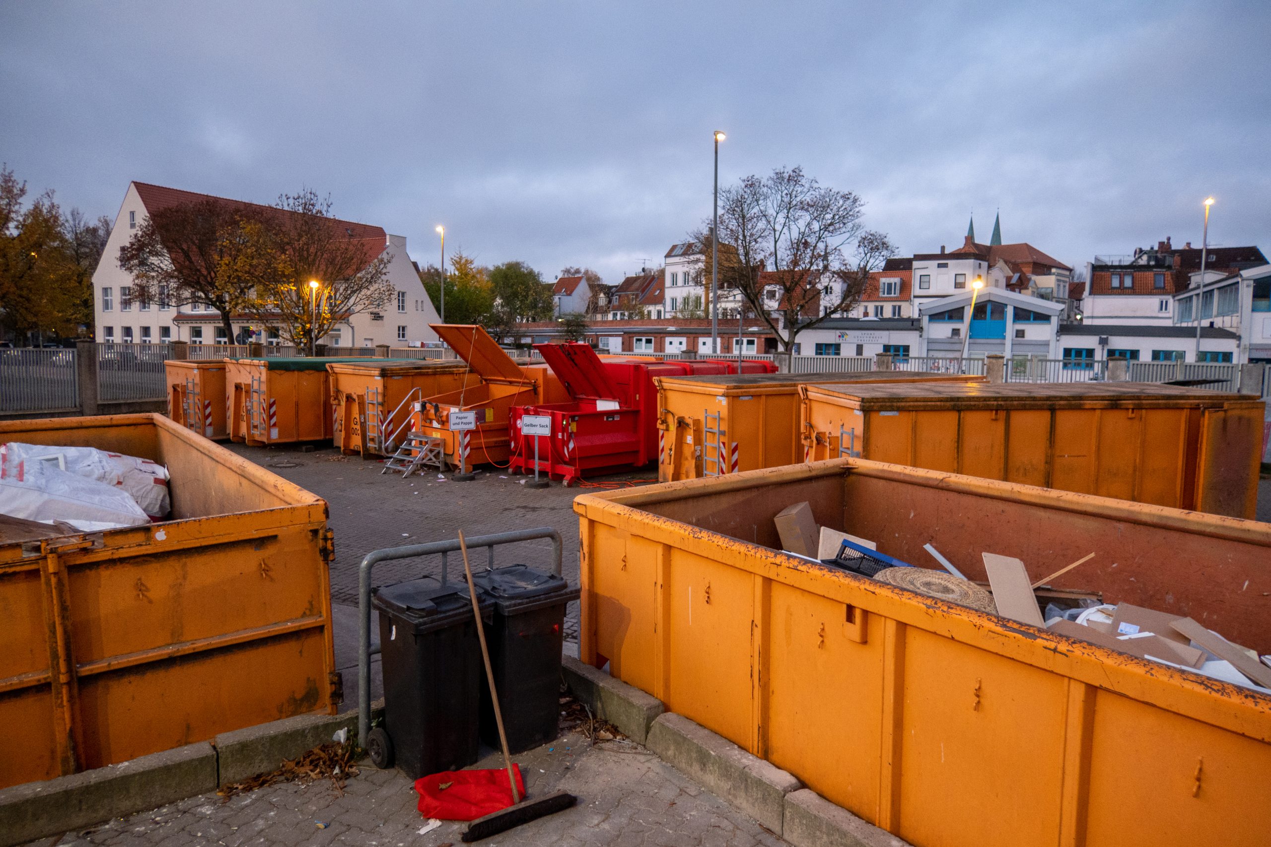 Abfallcontainer auf städtischem Recyclinghof bei Dämmerung.